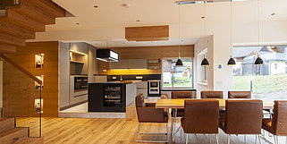 Moderne Küche in Schlammgrau mit Holz und großem Esstisch