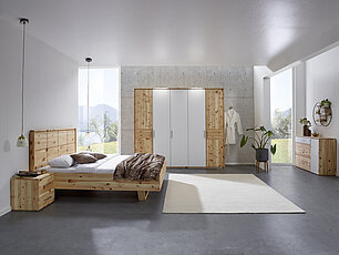Modernes Zirbenschlafzimmer mit Bett und elegantem Schrank