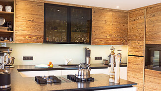 Moderne Altholzküche mit Glasschrank