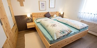 Modernes Zirbenbett mit Nachtkästchen