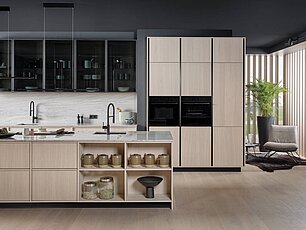 Moderne schlichte Küche mit hellen Fronten und Glasoberschränken