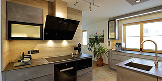 Küche in Betonoptik kombiniert mit einer Rückwand aus Holz