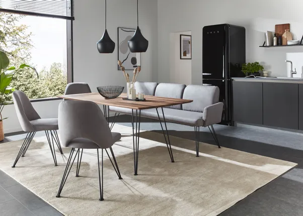 Moderne Essgruppe mit grauen Stühlen und Holz-Tisch in heller Küche mit schwarzem Kühlschrank