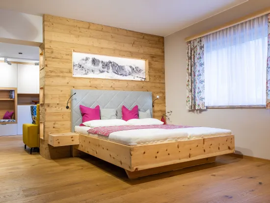 Modernes Zirbenbett mit Kopfteil mit Lodenstoff