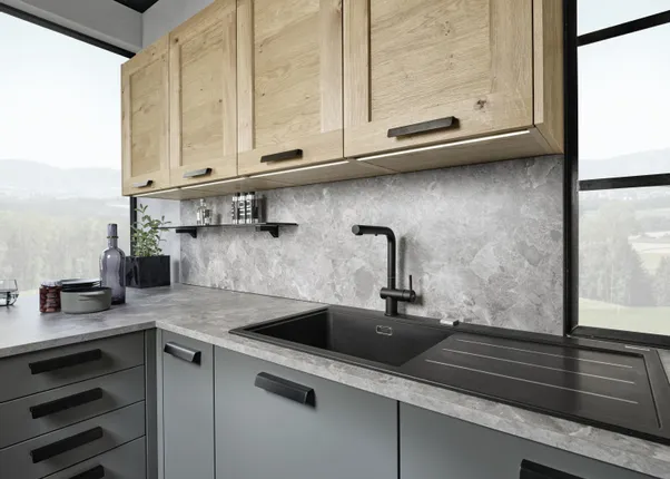 Moderne Küche mit grauer Arbeitsplatte, Holzoberschränken und schwarzer Spüle vor Panoramafenster