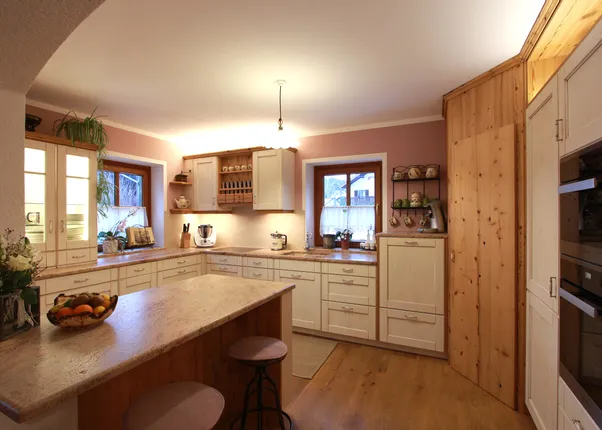 Gemütliche Landhausküche mit Holzfronten, Kücheninsel und modernen Einbaugeräten