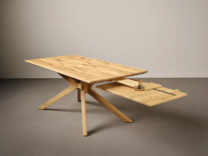 Ausziehbarer Holztisch mit modernem Design und schrägen Beinen auf grauem Hintergrund