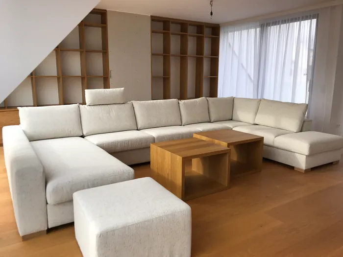 Modernes Wohnzimmer mit großer Ecksofa, Holz-Couchtischen und Regalwand