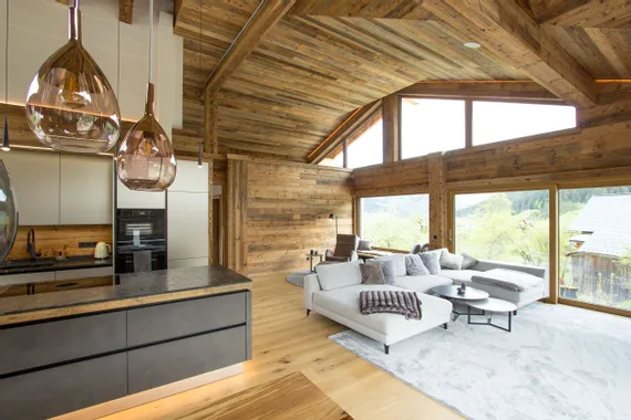 Modernes Chalet-Wohnzimmer mit Panoramafenstern, Holzverkleidung und gemütlicher Sitzecke