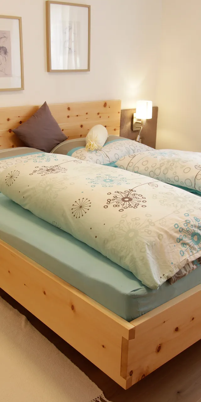Modernes Schlafzimmer mit Doppelbett aus hellem Holz und blauer Bettwäsche