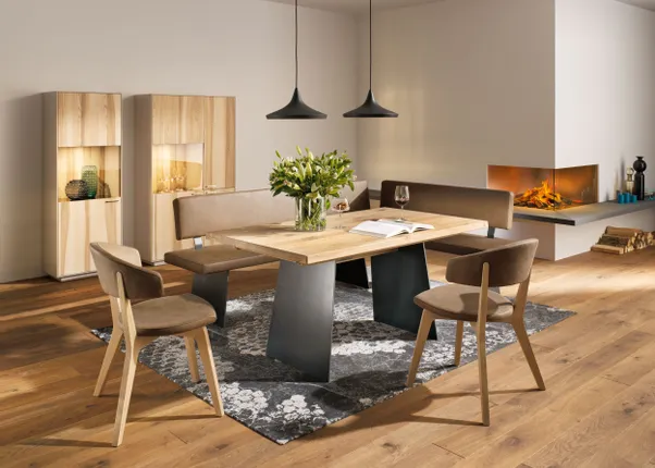 Moderner Essbereich mit Holztisch, Polsterstühlen und Kamin in wohnlicher Atmosphäre