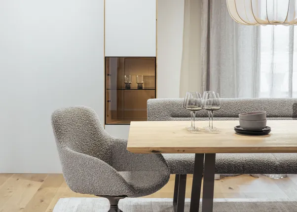 Modernes Esszimmer mit Holz-Esstisch, grauen Polsterstühlen und eleganter Hängelampe