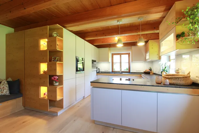 Moderne offene Küche mit Holzdecke, Kochinsel und integriertem Regal mit Beleuchtung