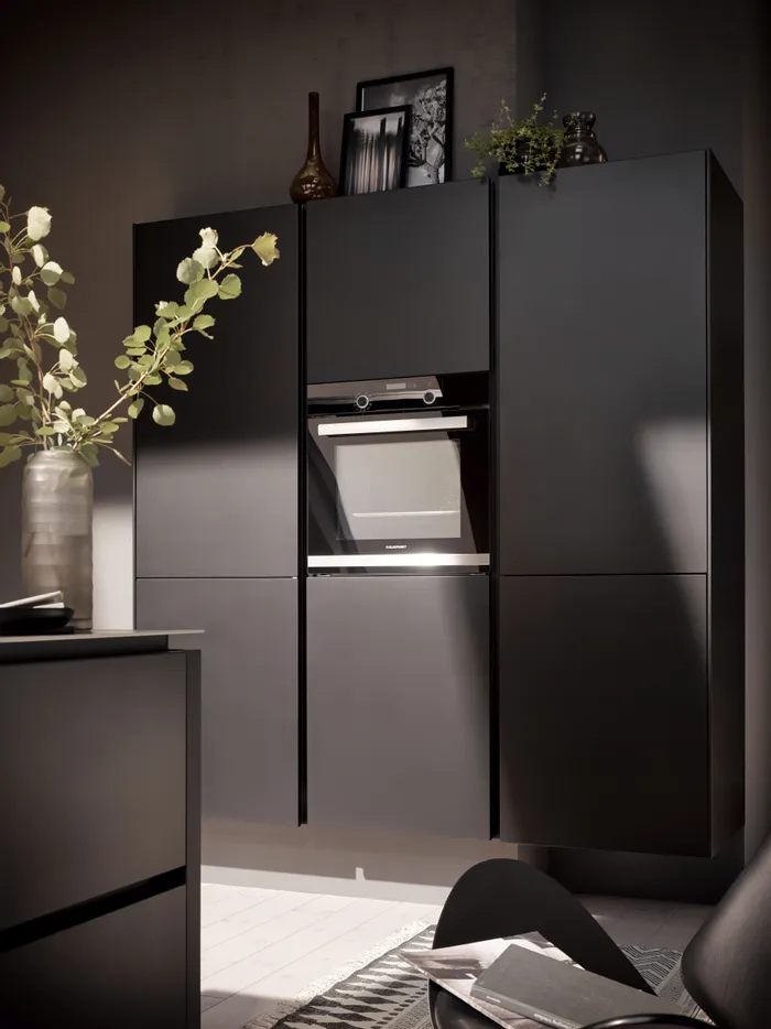 Moderne schwarze Küchenzeile mit eingebautem Backofen und stilvoller Dekoration