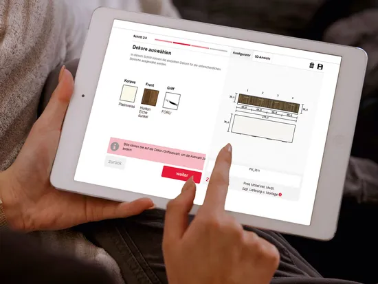 Person nutzt Tablet mit Möbel-Konfigurator zur Auswahl von Dekoren