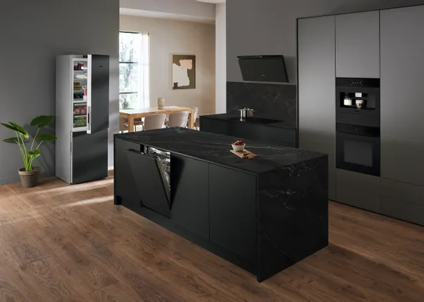 Moderne schwarze Einbauküche mit Kücheninsel, offenem Geschirrspüler und stilvollem Kühlschrank