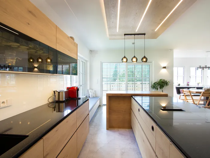 Moderne Holzküche mit schwarzer Arbeitsplatte