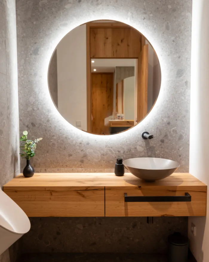Modernes Badezimmer mit rundem Spiegel, Holzwaschtisch und Aufsatzwaschbecken