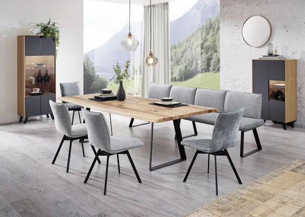 Modernes Esszimmer mit Holztisch, grauen Polsterstühlen und Panoramablick auf die Berge