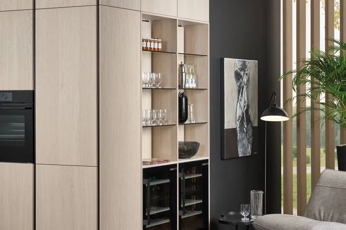 Moderne Küche mit hellen Holzfronten, Einbaugeräten und offener Regalwand mit Gläsern und Flaschen