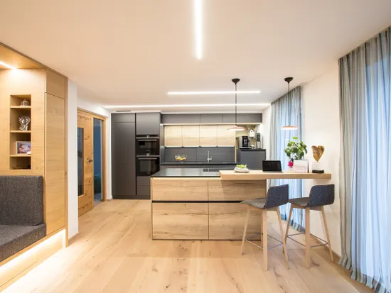 Moderne Küche mit Holzdetails, Kochinsel, Hockern und großen Fenstern mit Vorhängen