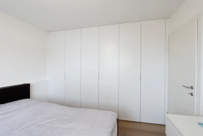 Modernes Schlafzimmer mit weißem Einbauschrank und minimalistischem Design