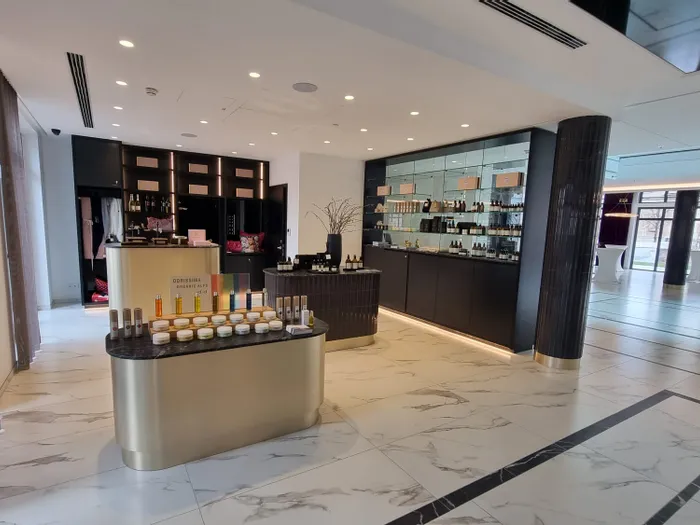 Moderner Kosmetiksalon mit Regalen voller Beauty-Produkte und Marmorboden