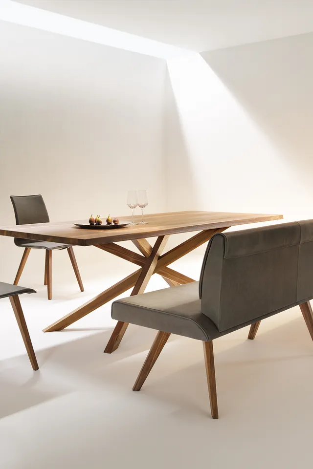 Moderne Essgruppe aus Holz mit grauer Polsterbank, zwei Stühlen und minimalistischem Design