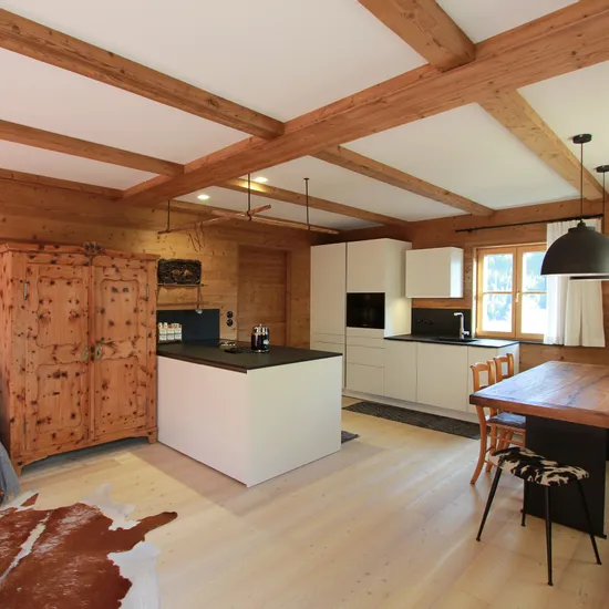 Moderne offene Küche mit Holzwänden, Essbereich und rustikaler Einrichtung im Alpenstil