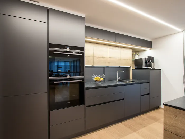 Moderne Einbauküche mit schwarzen Fronten, Holzakzenten und integrierten Siemens-Geräten