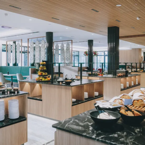 Modernes Frühstücksbuffet im Hotel mit frischem Gebäck, Obst und stilvollem Interieur