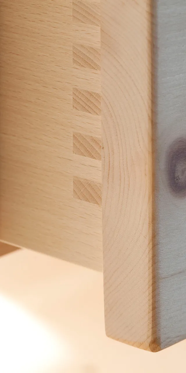 Detail einer Schwalbenschwanz-Holzverbindung an einer Schublade aus hellem Massivholz