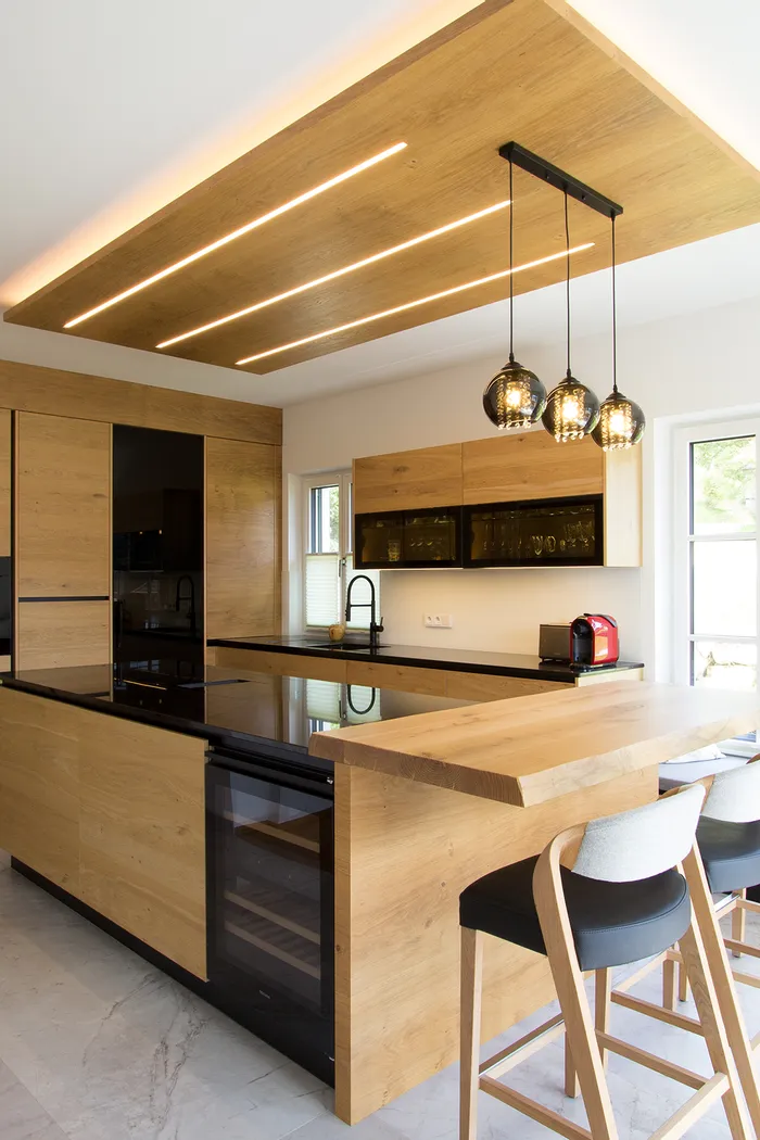 Moderne Küche mit Holzfronten, Kücheninsel, Hängelampen und großen Fenstern