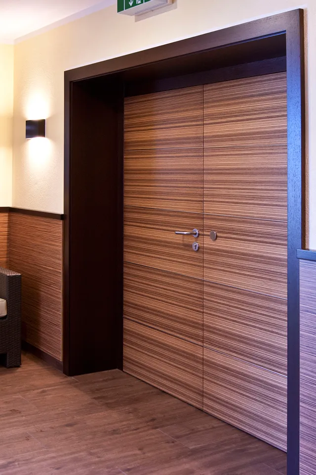 Modernes Hotelflur-Interieur mit Holztüren, Wandverkleidung und Sofa