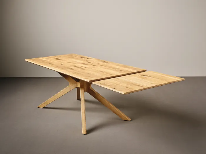 Ausziehbarer Esstisch aus hellem Holz mit modernem Design und schrägem Fußgestell