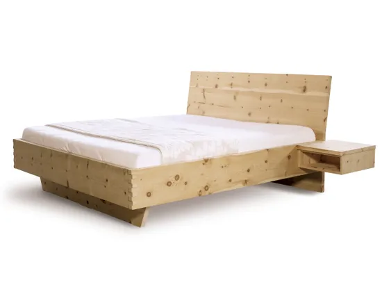 Massivholzbett aus heller Zirbe mit integriertem schwebendem Nachttisch