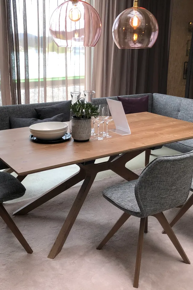 Moderne Essgruppe mit Holztisch, grauen Polsterstühlen und Eckbank in elegantem Wohnzimmerambiente