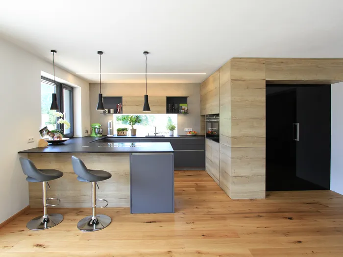 Küche mit Insel in Grau und Holzoptik, mit gemütlichem Sitzplatz