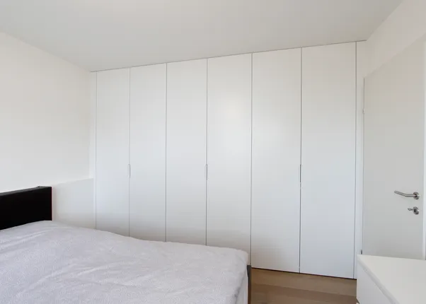 Modernes Schlafzimmer mit weißem Einbauschrank und minimalistischem Design