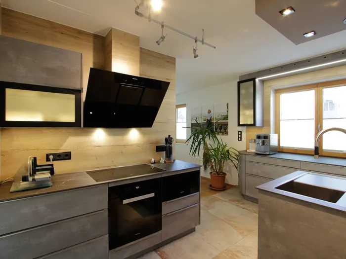 Moderne Einbauküche mit grauen Schränken, Kochinsel und Edelstahlarmatur