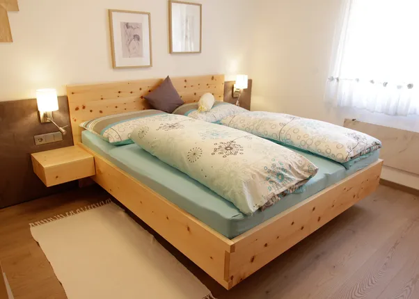 Modernes Schlafzimmer mit Doppelbett aus hellem Holz und blauer Bettwäsche