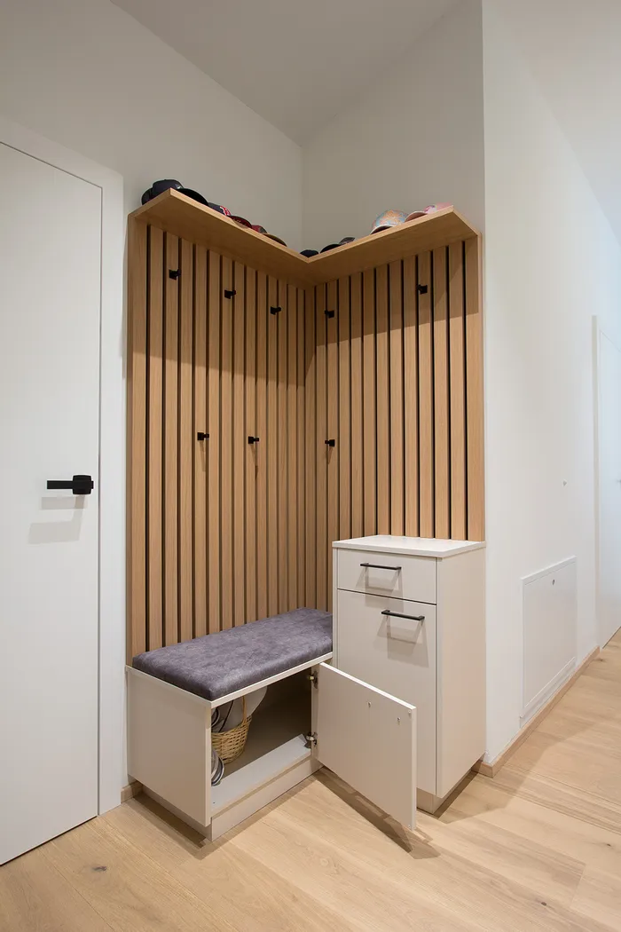 Moderne Garderobenecke mit Holzlamellen, Sitzbank und offener Schuhaufbewahrung