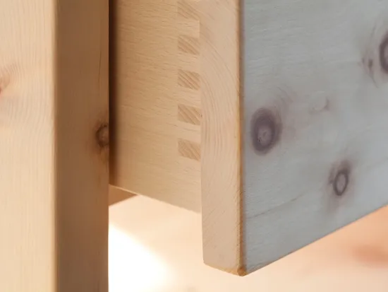 Detail einer Schwalbenschwanz-Holzverbindung an einer Schublade aus hellem Massivholz