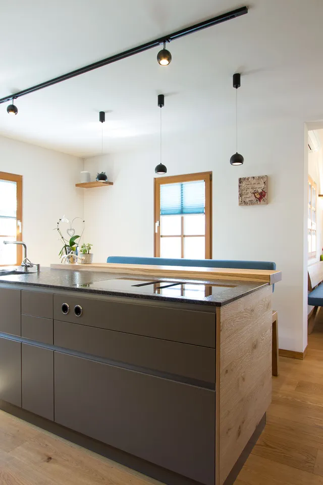 Moderne offene Küche mit Kochinsel, Holzfußboden und Essbereich mit blauen Stühlen