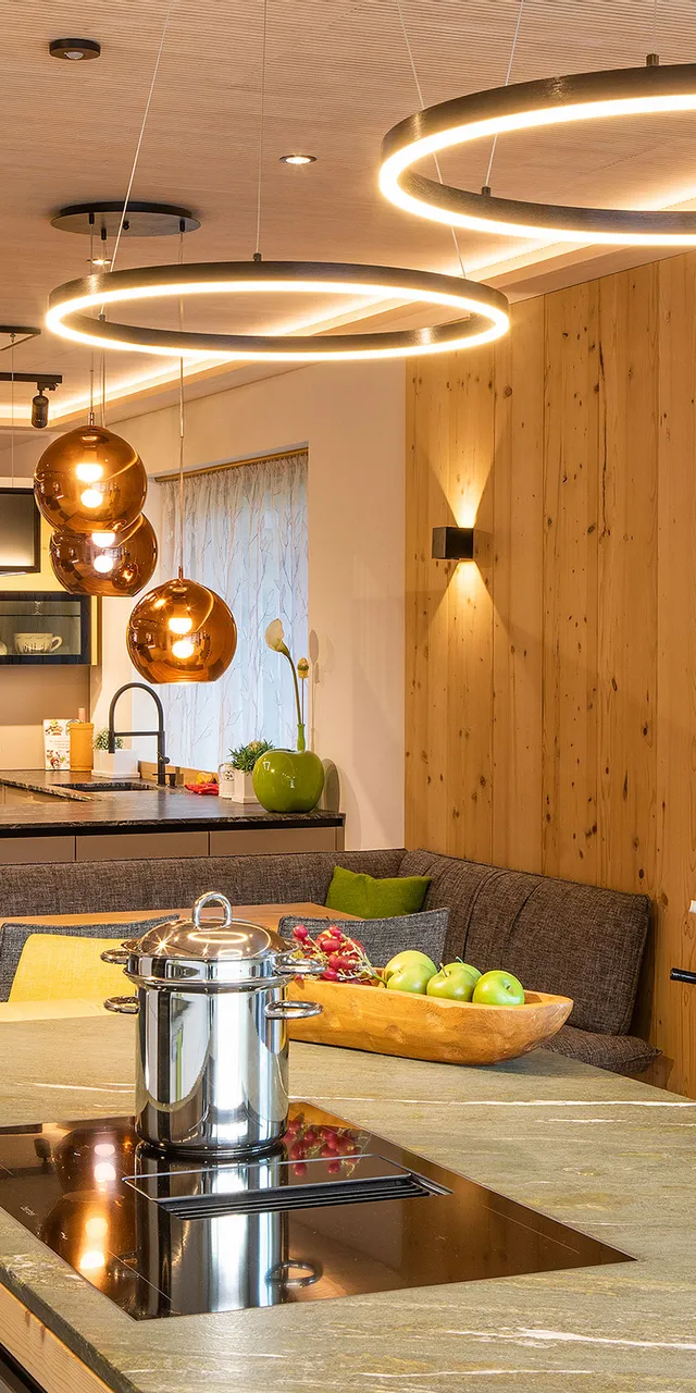 Moderne offene Küche mit Holzverkleidung, Kochinsel und eleganten Hängelampen