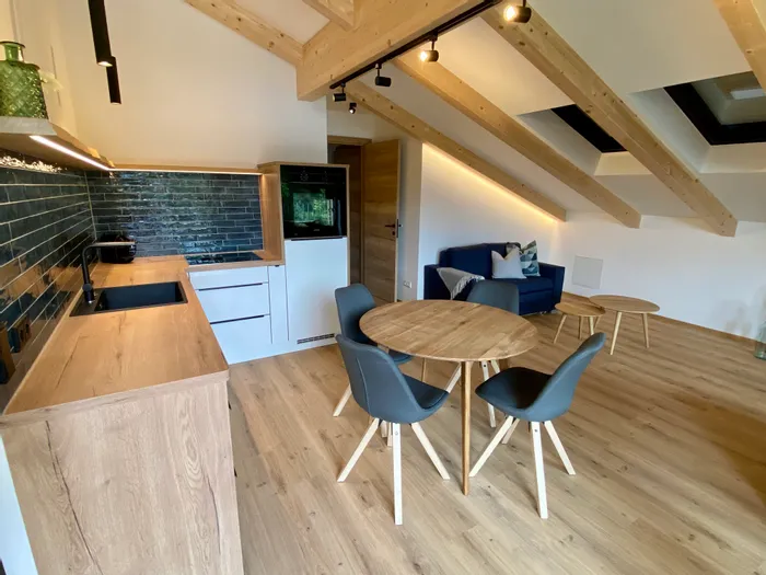 Moderne Ferienwohnung mit offener Küche, Essbereich und gemütlichem Wohnzimmer unter Holzbalkendecke