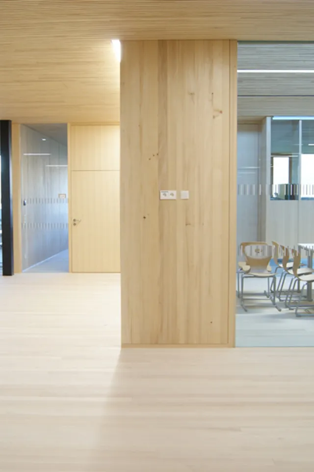 Moderner Konferenzraum mit Glaswand, Holzboden und minimalistischer Einrichtung