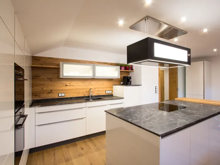 Moderne Einbauküche mit Kochinsel, Marmorarbeitsplatte und Holzrückwand