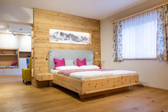 Modernes Zirbenbett mit Kopfteil mit Lodenstoff