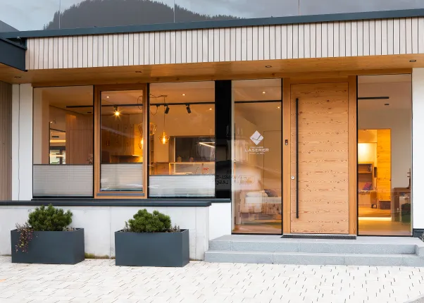 Moderne Holzfassade mit Glasfront und Eingang zur Tischlerei Laserer